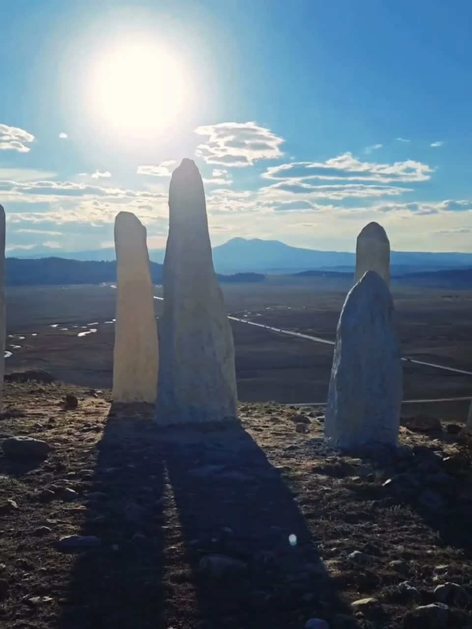 Ground-level view of the white standing stones in daylight